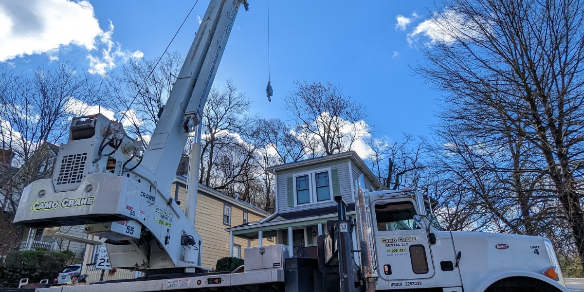 Winter Tree Work in Cincinnati: Why Smart Homeowners Get Estimates Now 3 Heavy-duty crane truck stabilized with outriggers and cones on a Cincinnati residential street, used by Lefke Tree Experts crew for winter tree removal.